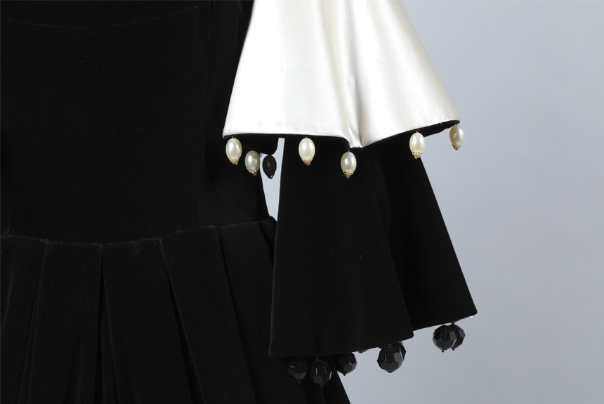 Detalle de manga de vestido con piedras facetadas de acrílico colgando de sus extremos.