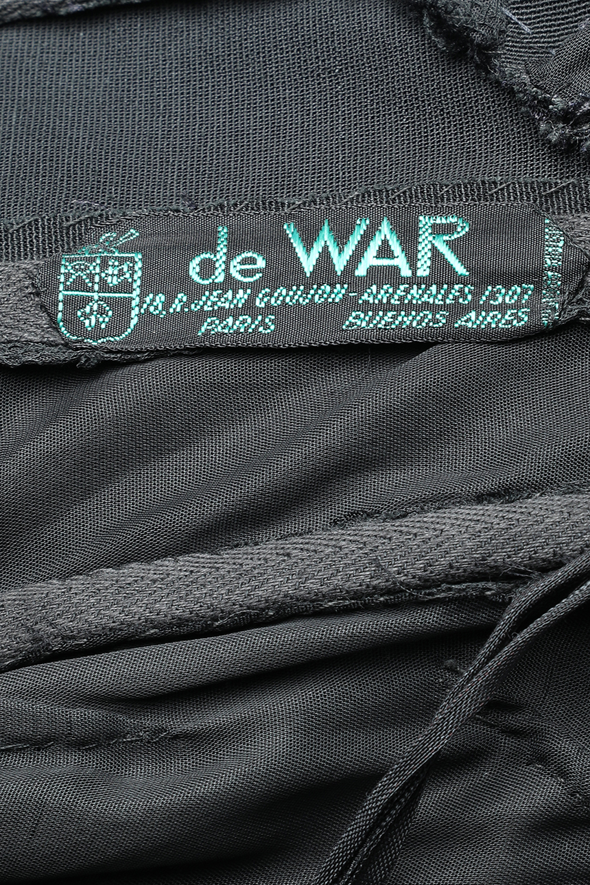 Detalle de etiqueta de prenda De WAR. Se lee 18, R. Jean Goujon Paris - Arenales 1307 Buenos Aires.