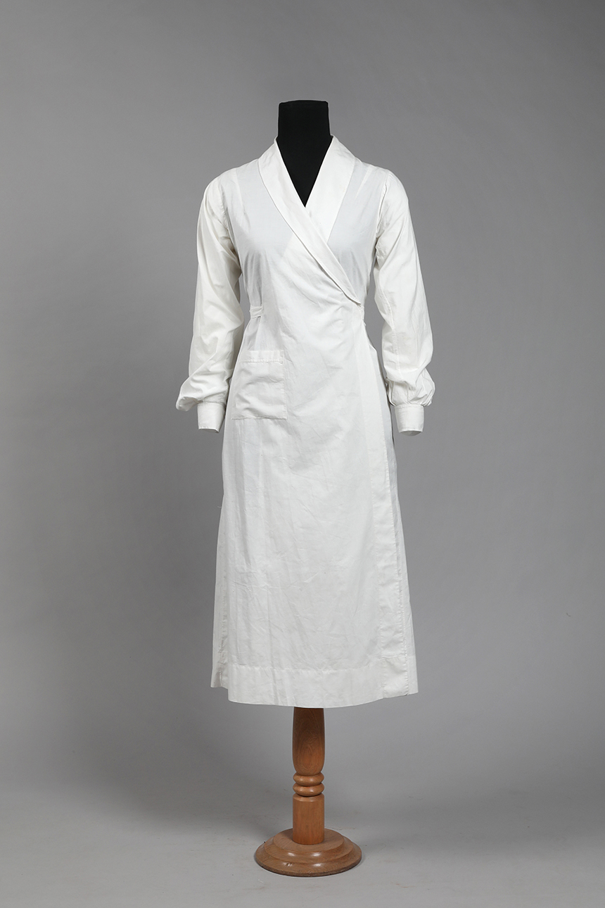 Guardapolvo blanco de mangas largas, realizado en algodón por Gath & Chavez entre 1940 y 1950.